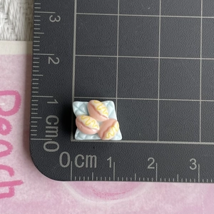 Detailed macro view showing the 1.2cm scale of miniature resin bread dessert for DIY crafts