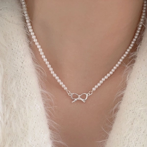 Elegant 925 sterling silver bow knot pearl necklace worn by a model on white fur