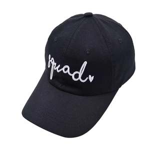 Detail of white squad embroidery and heart design on a black cotton baseball cap