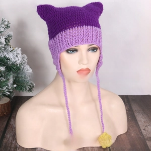 Detail of knitted cat ear hat with purple stitching, earflaps, and yellow flower accents