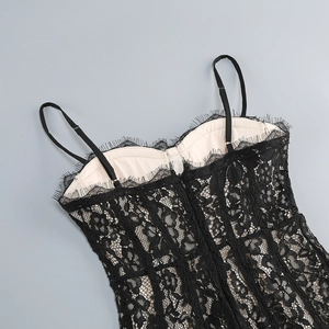 Dettaglio del vestito in pizzo nero con fodera beige, stecche e spalline sottili regolabili
