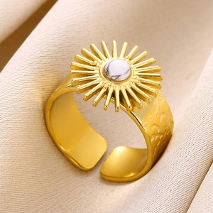 Macro shot of gold sunflower ring with white marble stone on beige textured cloth