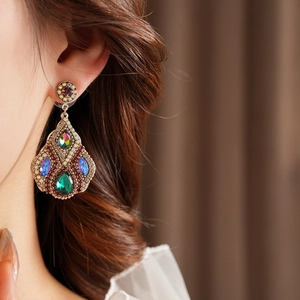 Gros plan d'une boucle d'oreille vintage de luxe avec strass colorés sur un mannequin