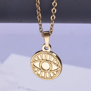 Detailed view of golden round evil eye pendant with polished metal chain links