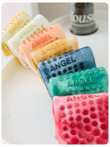 Detailed macro view of non-slip silicone grip patterns on colorful cotton pilates socks