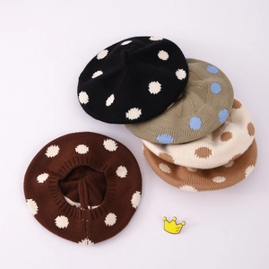 Flat lay of colorful knitted polka dot berets in black, khaki, beige, and brown colors