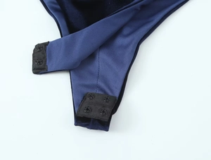 Detail shot of the navy velvet bodysuit featuring durable snap button closures at the crotch