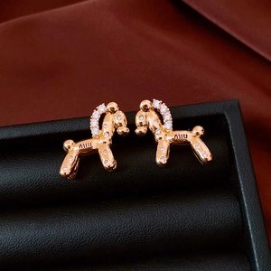 Close-up of golden balloon dog stud earrings with white zircons and miu engraving