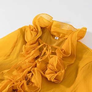 Detail of yellow ruffled neckline with drawstring tie and soft chiffon texture