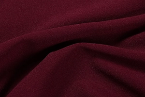 Detailed close-up of dark wine red sequin dress fabric showing fine texture and drape