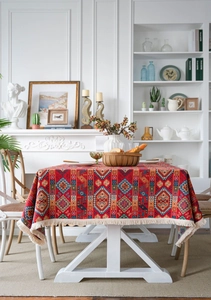Close-up of red ethnic tablecloth with geometric patterns and fringe in a cozy living room