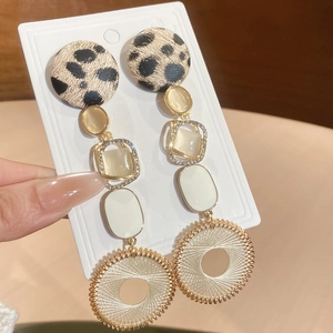 Détail de la boucle d'oreille avec perle léopard et anneau tressé métallique