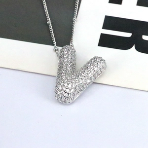 Macro shot of silver initial V pendant necklace with micro-pave zircon crystals