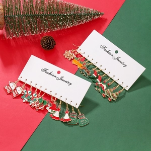 Detail view of five pairs of enamel Christmas earrings featuring Santa and reindeer designs