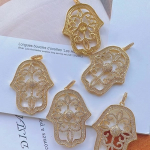 Detailed view of hollow copper Hamsa Hand pendants with sparkling zircon micro-pave