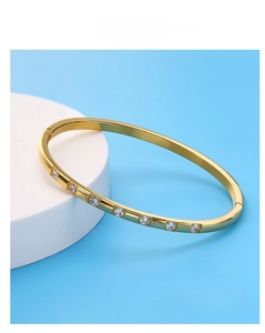 Detail of 18K gold-plated titanium steel bangle featuring seven sparkling round crystals