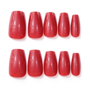 Detailed view of ten glossy cherry red coffin nails in medium length trapezoid shape