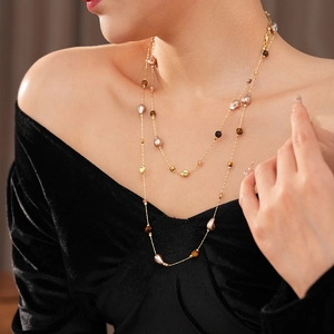 Dettaglio dell'elegante collana a doppio strato in oro con occhio di tigre e perle