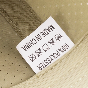 Detailed laundry label on breathable khaki polyester mesh cap showing material and washing instructions