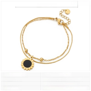 Detail of double-layer gold stainless steel bracelet with a sunflower resin charm