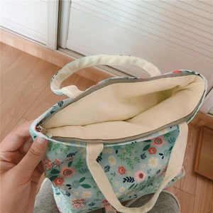 Detail of floral canvas tote bag featuring secure zipper closure and spacious inner lining