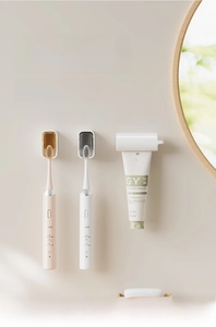 Detail of wall-mounted toothbrush holder set with automatic toothpaste dispenser in a bathroom