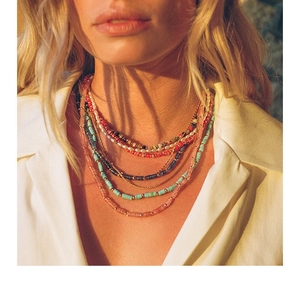 Detail of layered bohemian necklace with colorful natural stone beads and gold accents