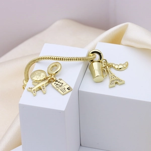Gold beaded travel bracelet with airplane, Eiffel Tower and Paris charms on silk