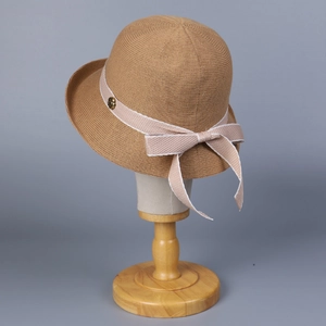 Detailed texture of women's knitted sun hat with grosgrain ribbon and metal button