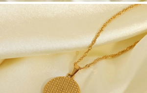 Macro shot of gold starburst pendant necklace with rope chain on silk fabric background