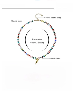 Detailed view of bohemian beaded necklace with natural stones and gold Z letter pendant