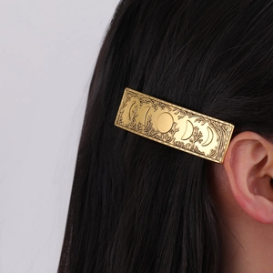 Vintage gold French hair clip featuring celestial moon phases and forest texture