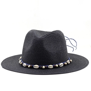 Close-up of black straw Panama hat with shell-adorned blue woven band detail
