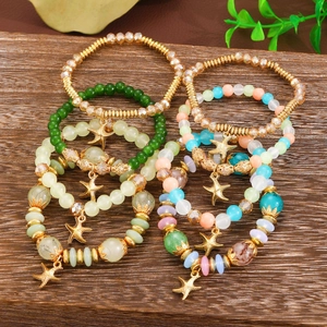 Dettaglio di bracciali bohémien a più strati con perline colorate e ciondolo a stella