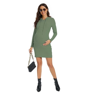Detail of green ribbed knit maternity dress showing drawstring hood and fabric texture