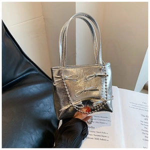 Detail of silver metallic wrinkled handbag with three bows and double pearl bead chains