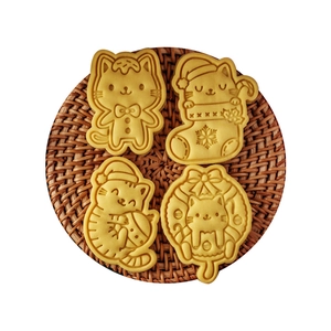 Cartoon Christmas cat cookie cutters showing four embossed kittens on a woven mat