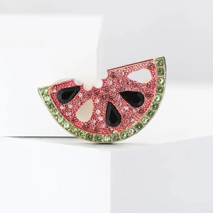 Detailed view of watermelon slice brooch with pink rhinestones and golden base