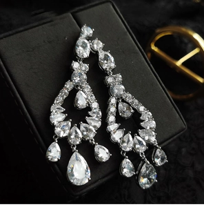 Macro view of teardrop hollow earrings with silver needle and sparkling zircon stones