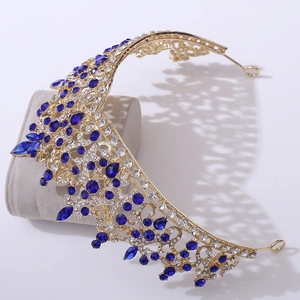 Detail of luxury gold crown with blue teardrop crystals and sparkling diamonds