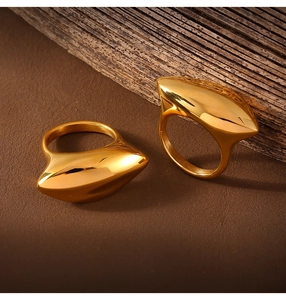 Macro shot of polished gold-plated stainless steel geometric ring on a wooden surface