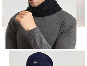 Détail du bonnet en maille bleu marine avec patch et du cache-col noir en tricot côtelé