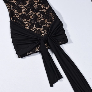Dettaglio in pizzo floreale nero con nastro decorativo su un abito aderente elegante