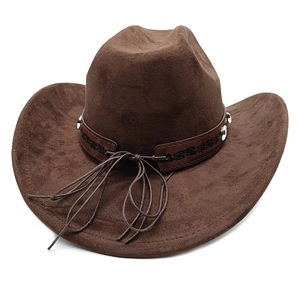 Detail of dark brown suede cowboy hat featuring a studded leather band and fringe tassels