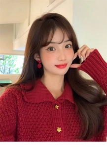 Close-up of golden floral-shaped buttons on a red knit cardigan for a stylish look