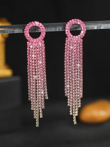 Macro detail of long tassel earrings with pink gradient rhinestones and alloy base