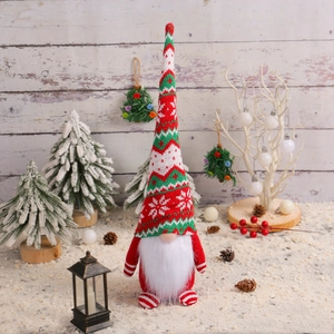 Knitted Christmas gnome decoration with long hat and white beard in festive winter scene