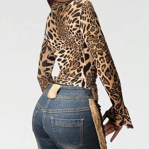 Detail of leopard print top and blue denim jeans with plush faux fur trim detail