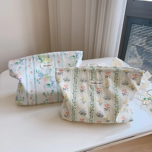 Detail of floral cotton makeup bags with simple wish labels on a white tabletop