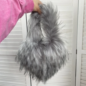 Detail view of light grey faux fur heart-shaped bag with soft texture and long plush